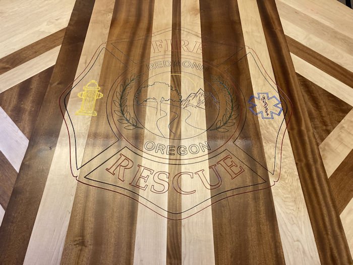 Redmond Fire & Rescue has its logo etched in the new firehouse kitchen table made at Redmond HS wood shop