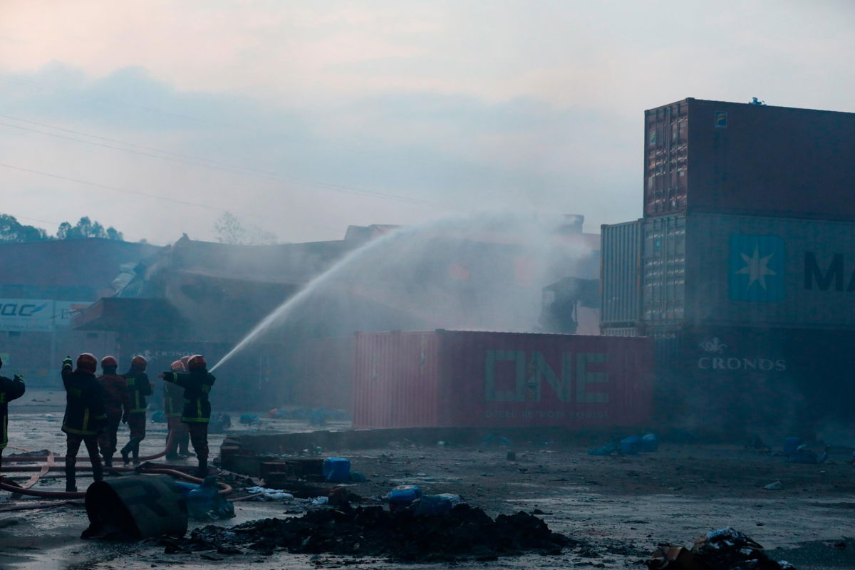 <i>AP</i><br/>Firefighters work to contain a fire that broke out at the BM Inland Container Depot