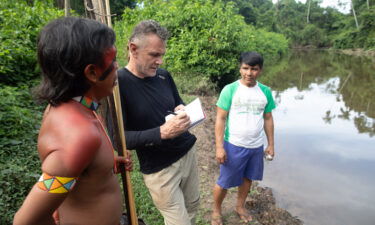 Brazilian authorities said on June 16 that a suspect had confessed to killing Dom Phillips and Bruno Pereira. Phillips (C) is pictured talking to two indigenous men in Aldeia Maloca Papiú