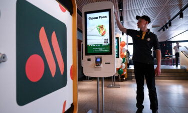 An employee cleans a self-ordering machine at the Russian version of a former McDonald's restaurant before the opening ceremony