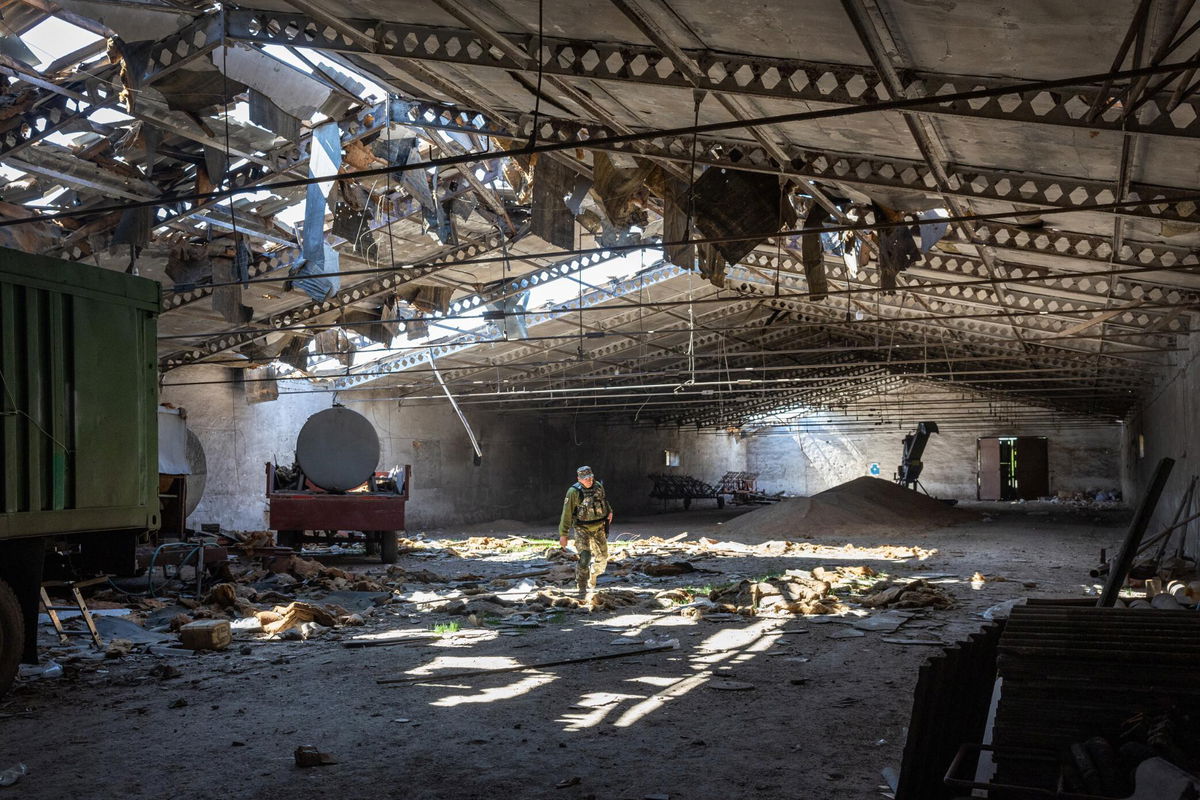 <i>John Moore/Getty Images</i><br/>A Ukrainian army officer inspects a grain warehouse in Kherson region after it was shelled by Russian forces on May 6.