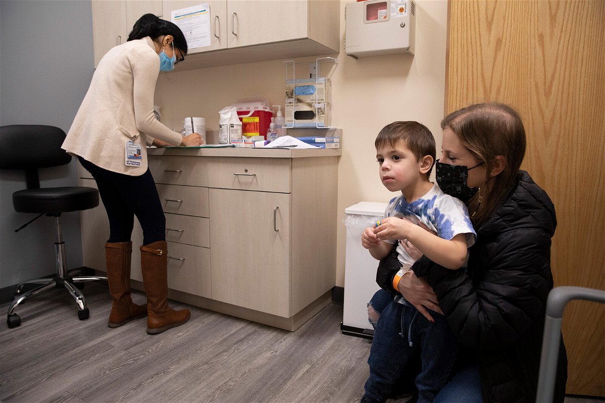 <i>Emma H. Tobin/AP</i><br/>Ilana Diener (right) holds her 3-year-old son during a Moderna Covid-19 vaccine trial on November 30