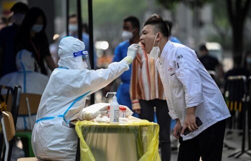 A health worker takes a swab sample from a man at a makeshift testing site outside a shopping mall in Beijing on June 15.