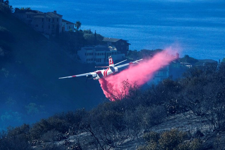 A plane drops retardant on a wildfire near homes Thursday, Feb. 10, 2022, in Laguna Beach, Calif.