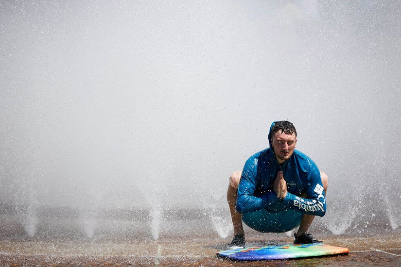 Jesse Moore cools off in the Salmon Street Springs fountain in Portland on Tuesday