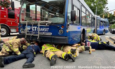A 28-year-old woman who was struck by a bus and pinned underneath it is recovering after she was rescued by firefighters in Connecticut Tuesday.