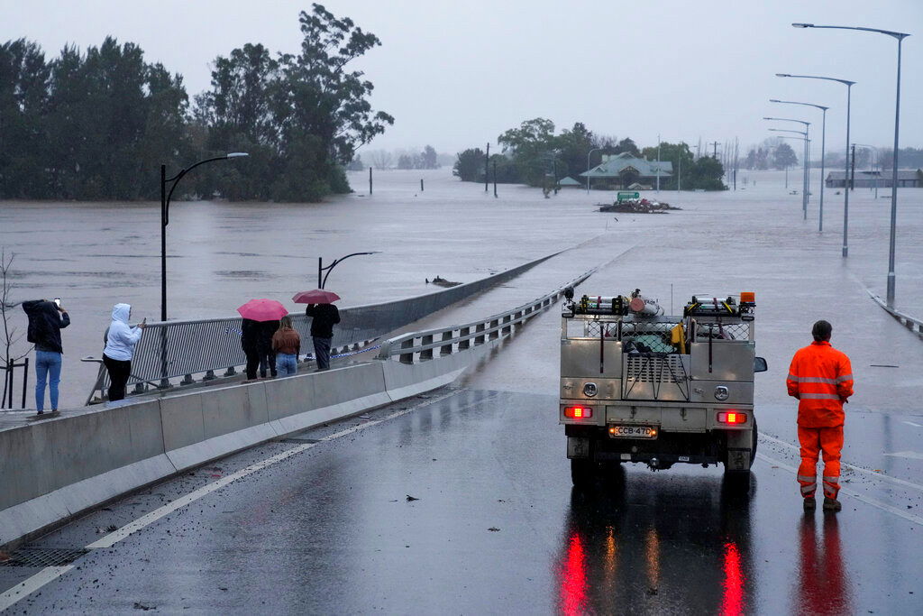 An emergency vehicle blocks access to the flooded Windsor Bridge on the outskirts of Sydney, Australia, Monday