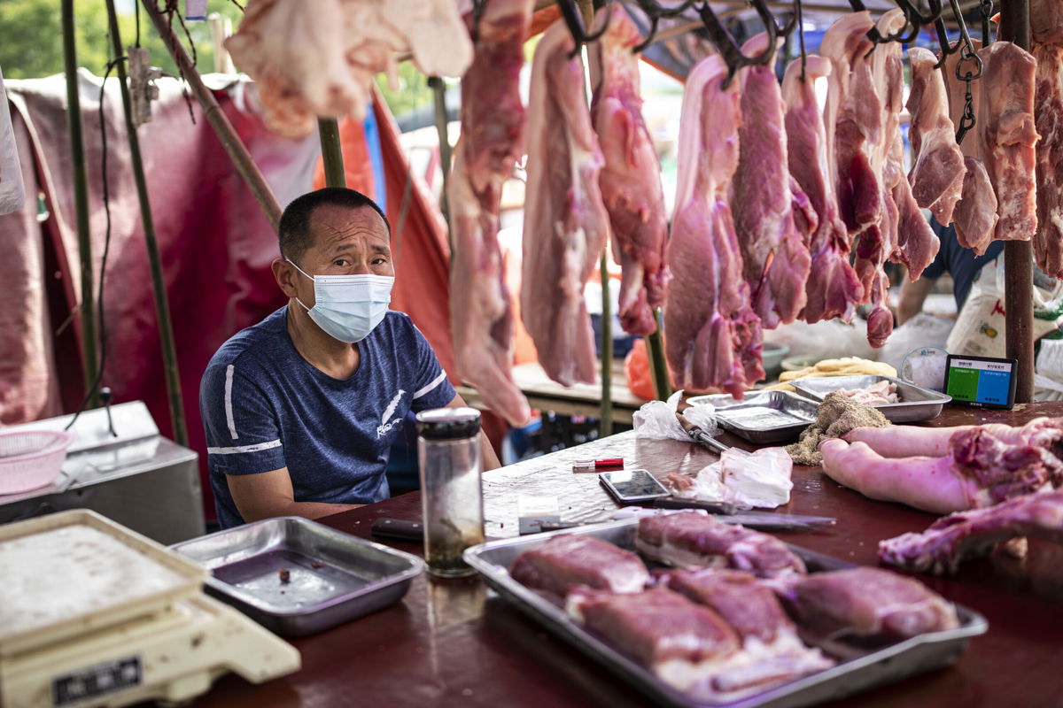 <i>Getty Images/Getty Images</i><br/>A vendor sells pork at an open market on May 31