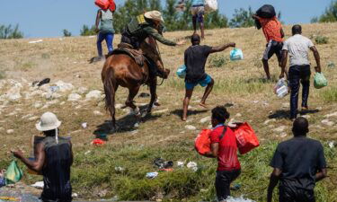 A United States Border Patrol agent on horseback tries to stop a Haitian migrant from entering an encampment on the banks of the Rio Grande near the Acuna Del Rio International Bridge in Del Rio