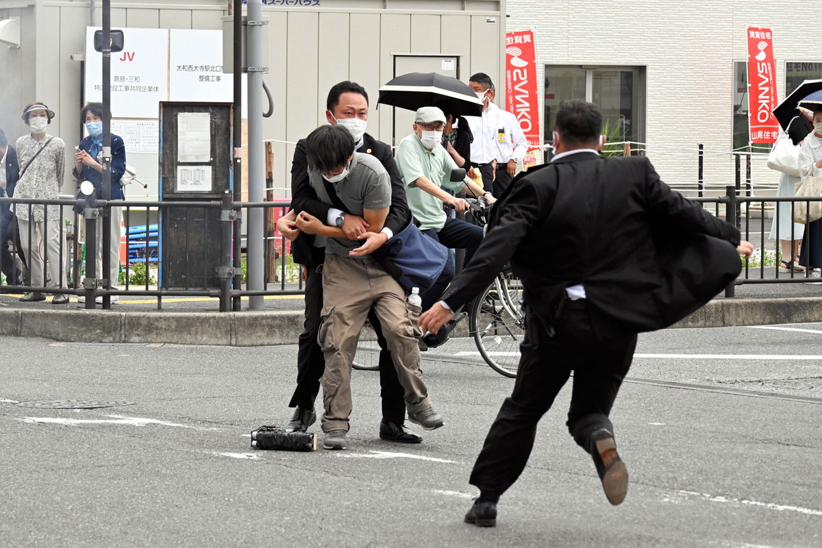 <i>The Asahi Shimbun/Getty Images</i><br/>Security police tackle to arrest a suspect who is believed to have shot former Prime Minister Shinzo Abe in front of Yamatosaidaiji Station on July 8