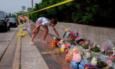 A mourner visits a memorial for the victims of a mass shooting at a Fourth of July parade