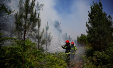Firefighters work to contain a fire near Louchats