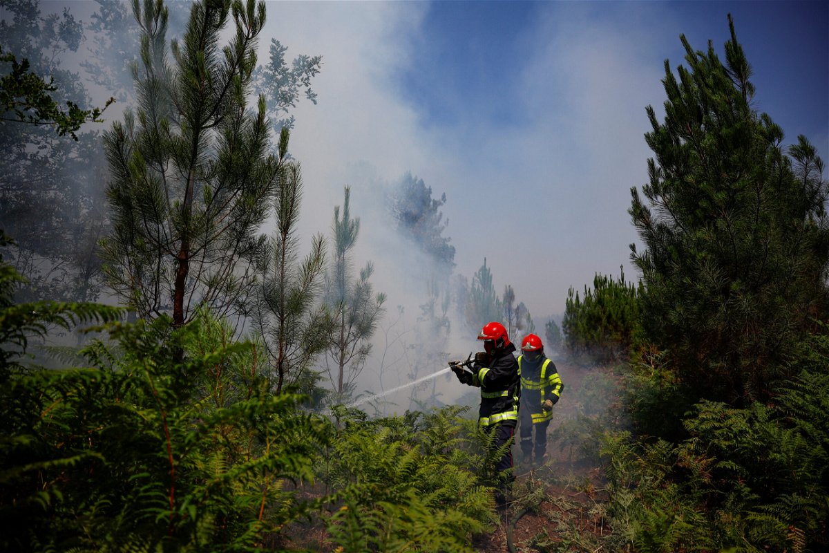 <i>Sarah Meyssonnier/Reuters</i><br/>Firefighters work to contain a fire near Louchats