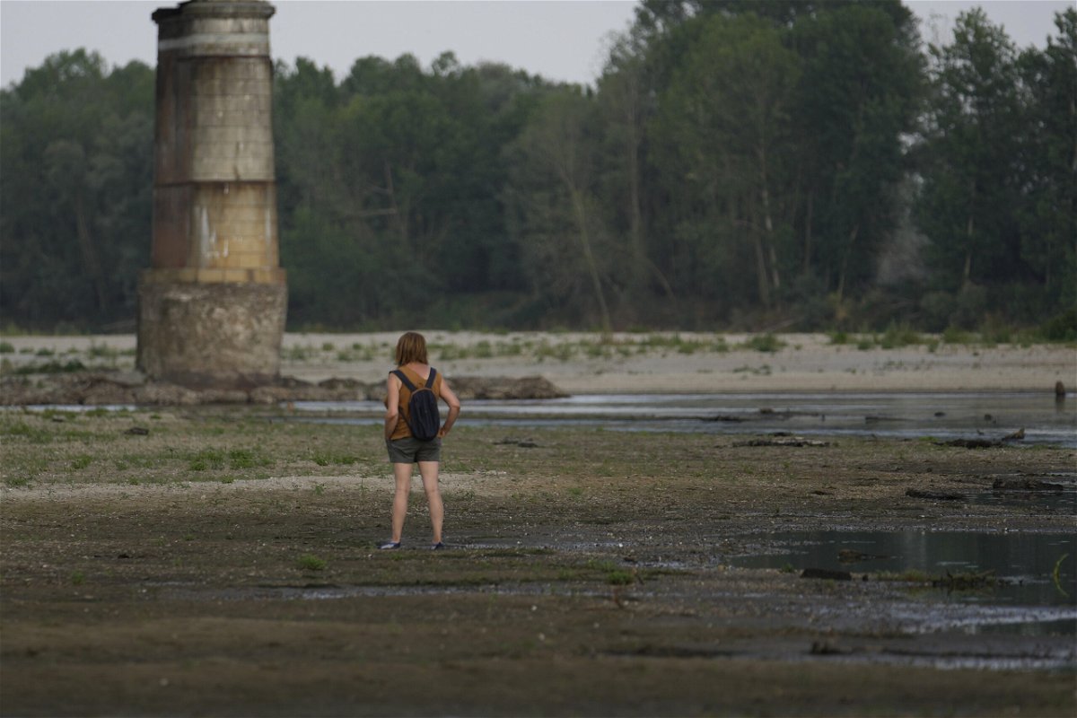 <i>Luca Bruno/AP</i><br/>A woman stands on the Po riverbed next to Ponte della Becca (Becca bridge) in Linarolo
