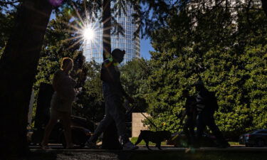 Pedestrians walk along a street during a heatwave in Dallas