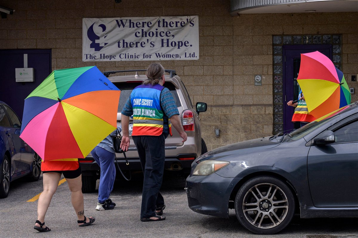<i>Angela Weiss/AFP/Getty Images</i><br/>Volunteer clinic escorts shield a patient from anti-abortion demonstrators at the Hope Clinic For Women in Granite City