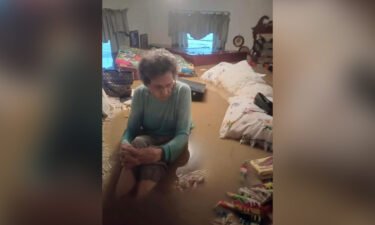 Mae Amburgey sits in floodwaters inside her home in Whitesburg