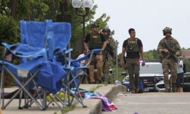 Law enforcement officers  investigate after the shooting at Highland Park