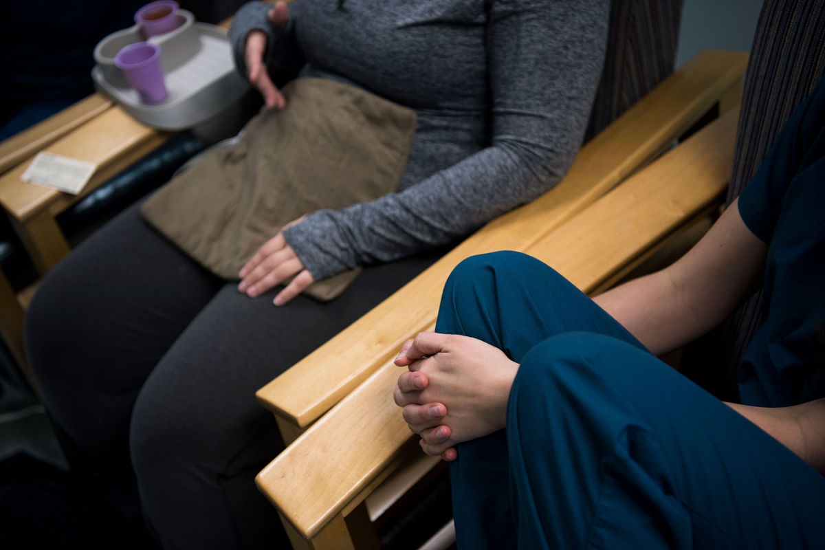 <i>Carolyn Van Houten/The Washington Post/Getty Images</i><br/>An abortion doula speaks with a patient after the procedure at Falls Church Healthcare Center in Virginia on November 24