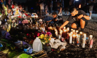 Mourners place water bottles at a makeshift memorial for the 53 migrants found dead in a semi-truck on the outskirts of San Antonio