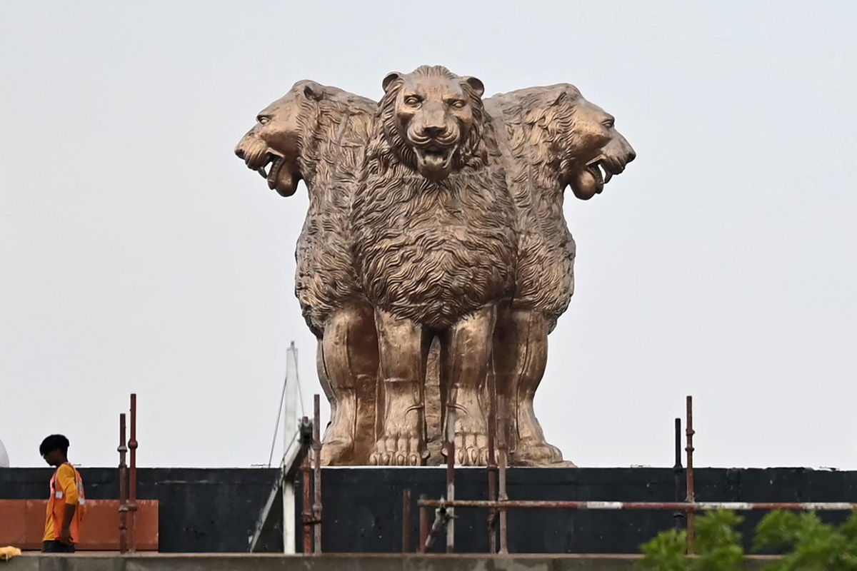 <i>Sajjad Hussain/AFP/Getty Images</i><br/>A worker walks past the newly inaugurated 'National Emblem' installed on the roof of the new Indian parliament building in New Delhi on July 12.