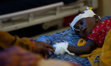 Fatima Abdullahi extends her hand to touch her 8 month old daughter Abdi