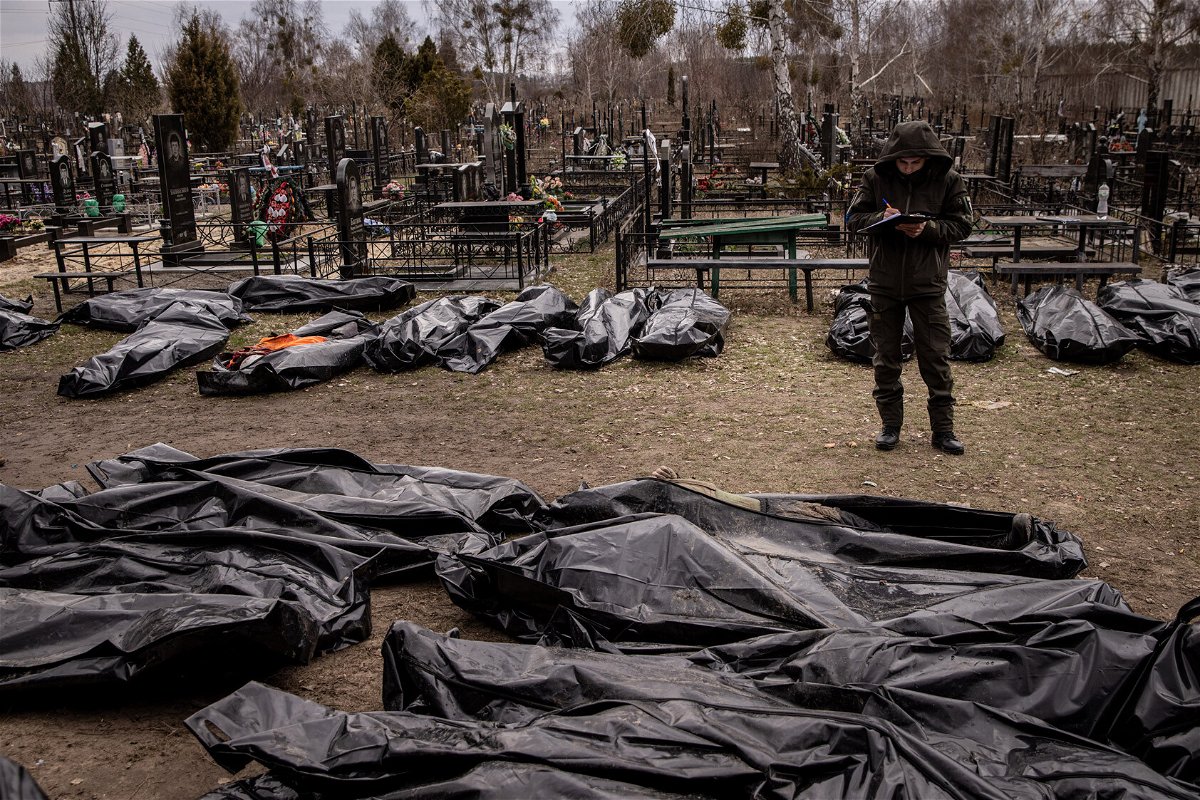 <i>Chris McGrath/Getty Images</i><br/>A man works to catalog some of 58 bodies of civilians killed in and around Bucha before they are transported to the morgue at a cemetery on April 6 in Bucha