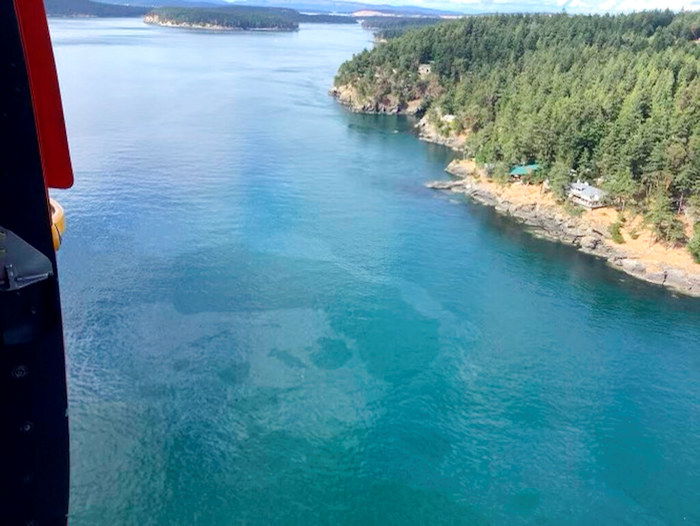 Saturday aerial photo released by the U.S. Coast Gaurd shows a diesel spill off the west coast of Washington's San Juan Island after a 49-foot fishing vessel sank with an estimated 2,600 gallons of fuel aboard