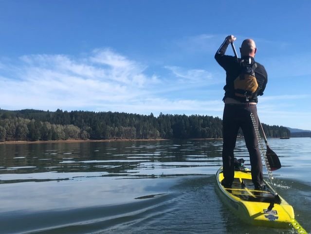 Stand Up Paddleboarder Andrew Hanson, wearing a life jacket with quick-release leash