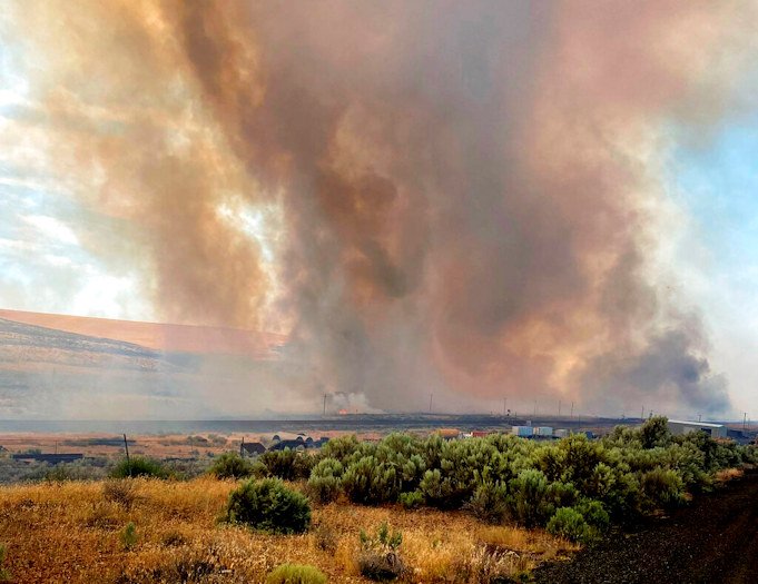 This photo provided by the Washington State Department of Transportation shows smoke from a wildfire burning south of Lind, Wash. on Thursday, Aug. 4, 2022