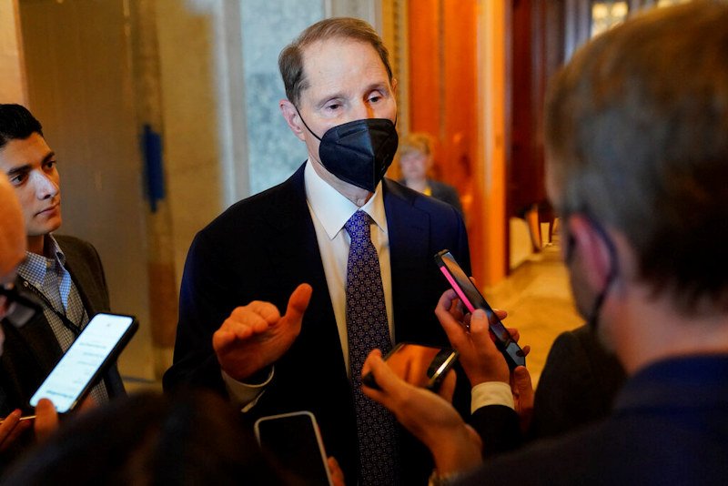 Sen. Ron Wyden, D-Ore., speaks with reporters on Capitol Hill in Washington, Saturday, Aug. 6