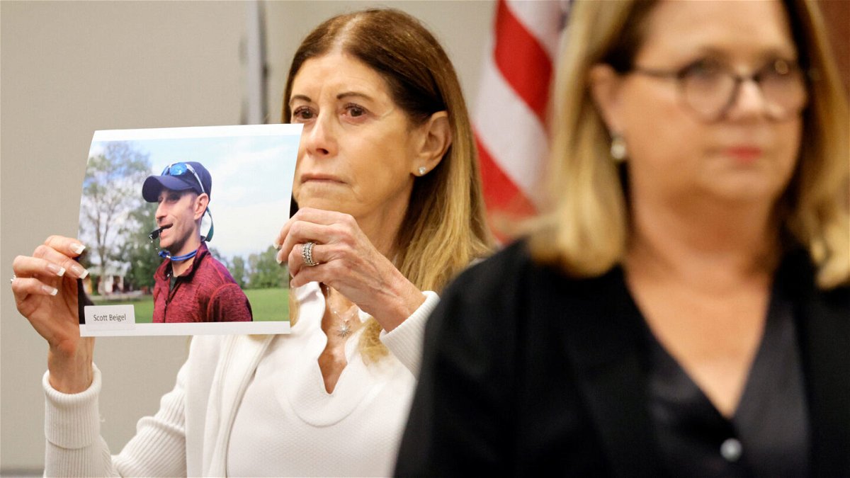 <i>Amy Beth Bennett/South Florida Sun Sentinel via AP</i><br/>Linda Beigel Schulman holds a photo of her son