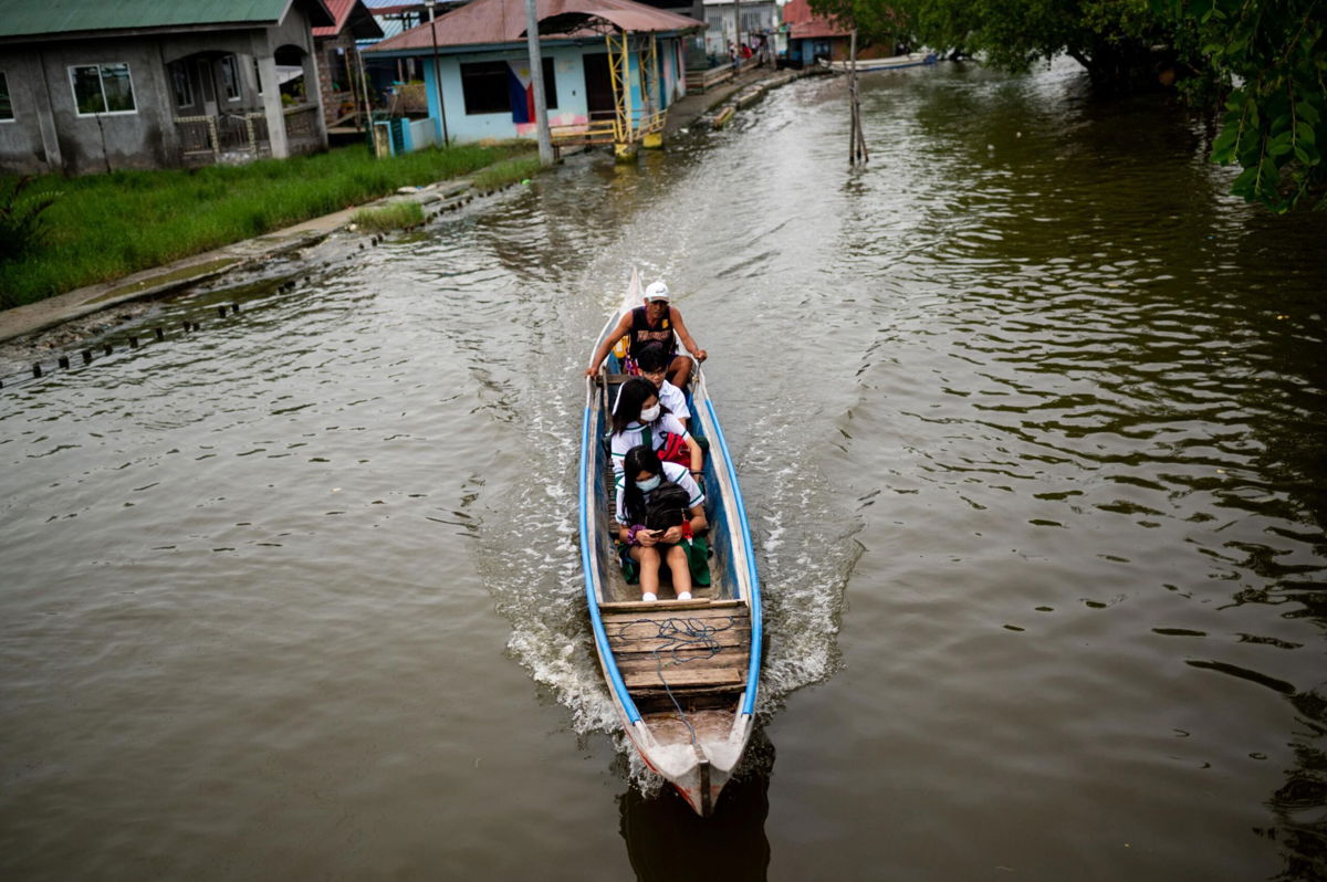 <i>Lisa Marie David/Reuters</i><br/>Students ride a boat to school during the first day of in-person classes in Macabebe