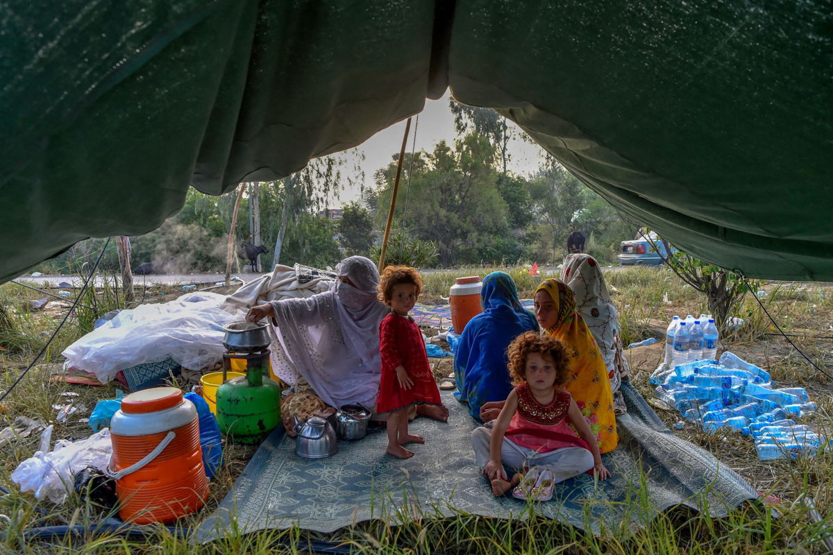 <i>Abdul Majeed/AFP/Getty Images</i><br/>Displaced people prepare for breakfast in their tents at a makeshift camp after fleeing from their flood-hit homes following heavy monsoon rains in Charsadda district of Khyber Pakhtunkhwa on August 29.