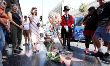People lay flowers by the star of late actor Olivia Newton-John on the Hollywood Walk of Fame in Los Angeles