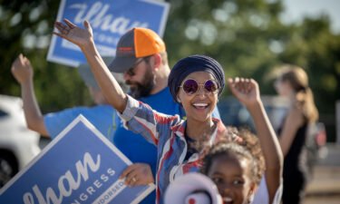 US Rep. Ilhan Omar waves to passersby for support during a voter engagement event on the corner of Broadway and Central Avenues in Minneapolis