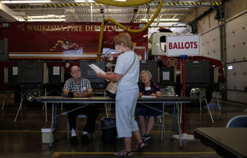 Poll workers and voters participate during Wisconsin's state primary day on August 9 in Waukesha