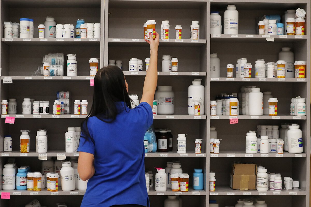 <i>George Frey/Getty Images</i><br/>A pharmacy technician grabs a bottle off a shelve at a pharmacy in Midvale