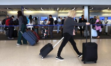 Travelers walk with their luggage at San Francisco International Airport on July 1 in San Francisco