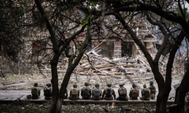 Ukrainian soldiers sit at the shelling scene of a destroyed school in Kramatorsk. Amnesty International said it "deeply regrets the distress and anger" caused by a report the group published on the Ukrainian military's fighting tactics
