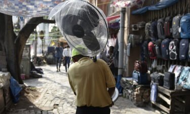 A man carries a pedestrial fan amid a heat wave in Kolkata