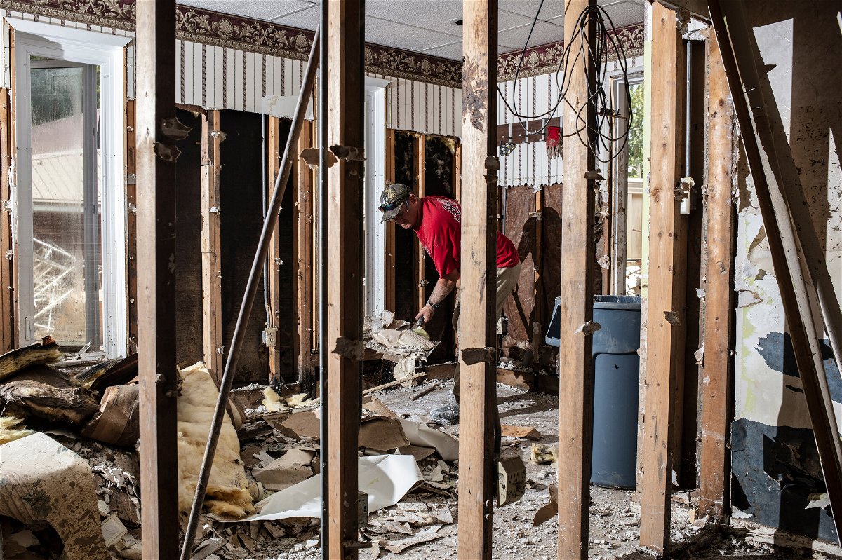 <i>Bryan Anselm/Redux for CNN</i><br/>A friend helps tear out drywall at Sam Quillen's damaged property in Fleming-Neon