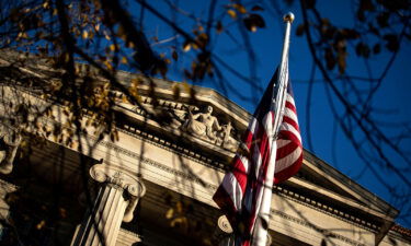 An American flag waves outside the Department of Justice Building in Washington in December 2020. The FBI's process for receiving reports of violent threats or harassment against election officials is not built to handle the volume of reports.