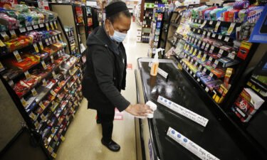 A grocery cashier sanitizes a checkout lane and the pandemic has created more tasks at work and at home.