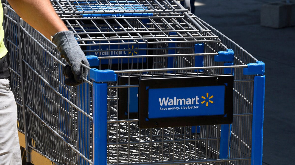<i>Robyn Beck/AFP via Getty Images</i><br/>An employee gathers shopping carts at a Walmart in Burbank