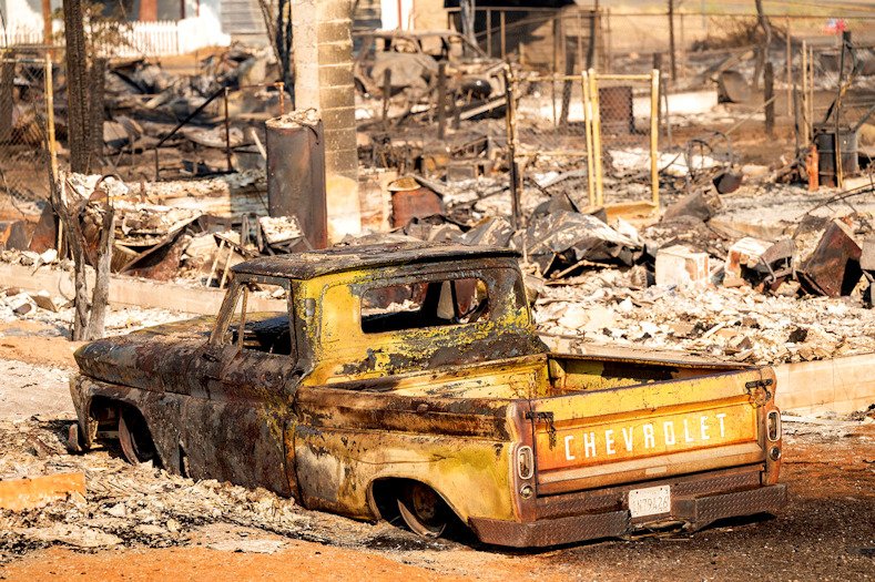 A scorched pickup truck sits in front of a Wakefield Avenue home destroyed by the Mill Fire on Saturday, Sept. 3, in Weed, Calif. 
