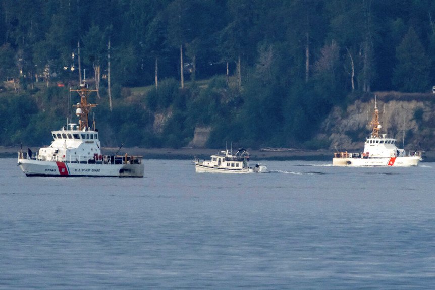A pair of U.S. Coast Guard vessels search the area near Freeland, Wash., on Whidbey Island north of Seattle where a chartered floatplane crashed 