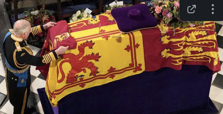 <i>Jonathan Brady/Pool Photo via AP</i><br/>King Charles III places the Queen's Company Camp Colour of the Grenadier Guards on his mother's coffin during the committal service that was held at St. George's Chapel in Windsor Castle on September 19.