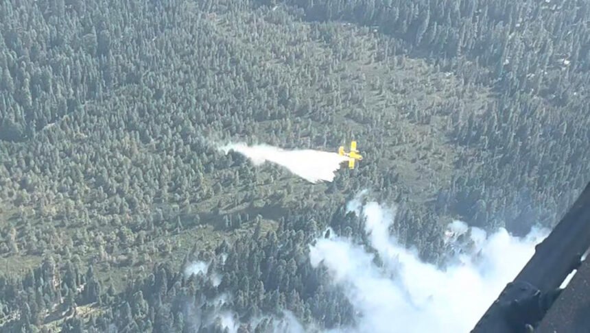 Super Scooper plane drops water from Cultus Lake on leading edge of Cedar Creek Fire