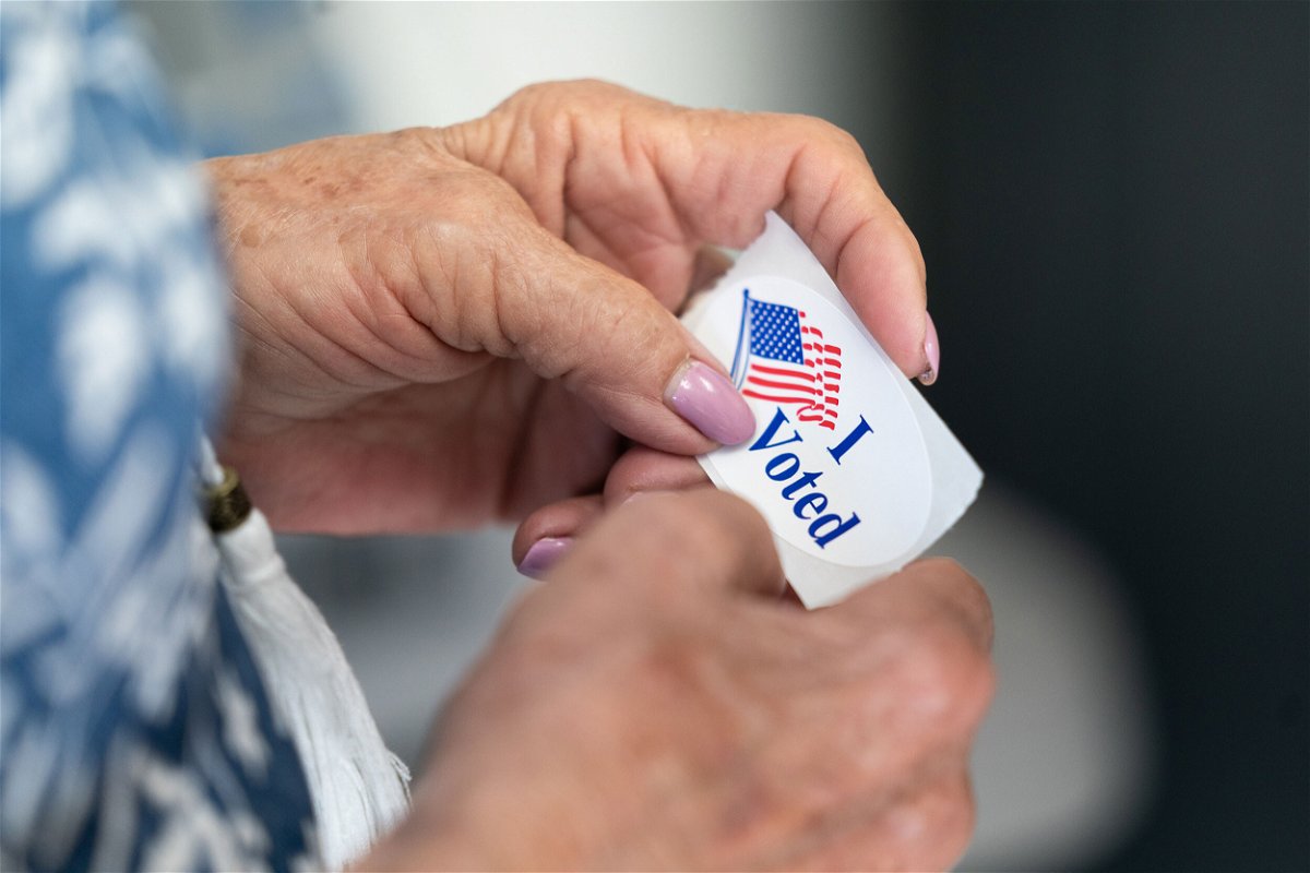 <i>Sean Rayford/Getty Images</i><br/>A poll worker holds a sticker that reads